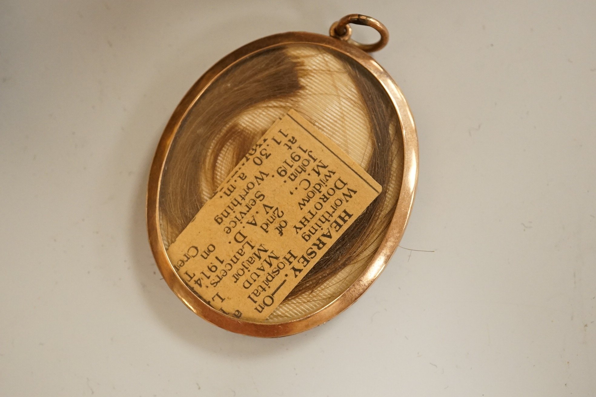 A large cloisonné enamel box containing a cast mask handle, an oval hair pendant, coins and medals, etc.